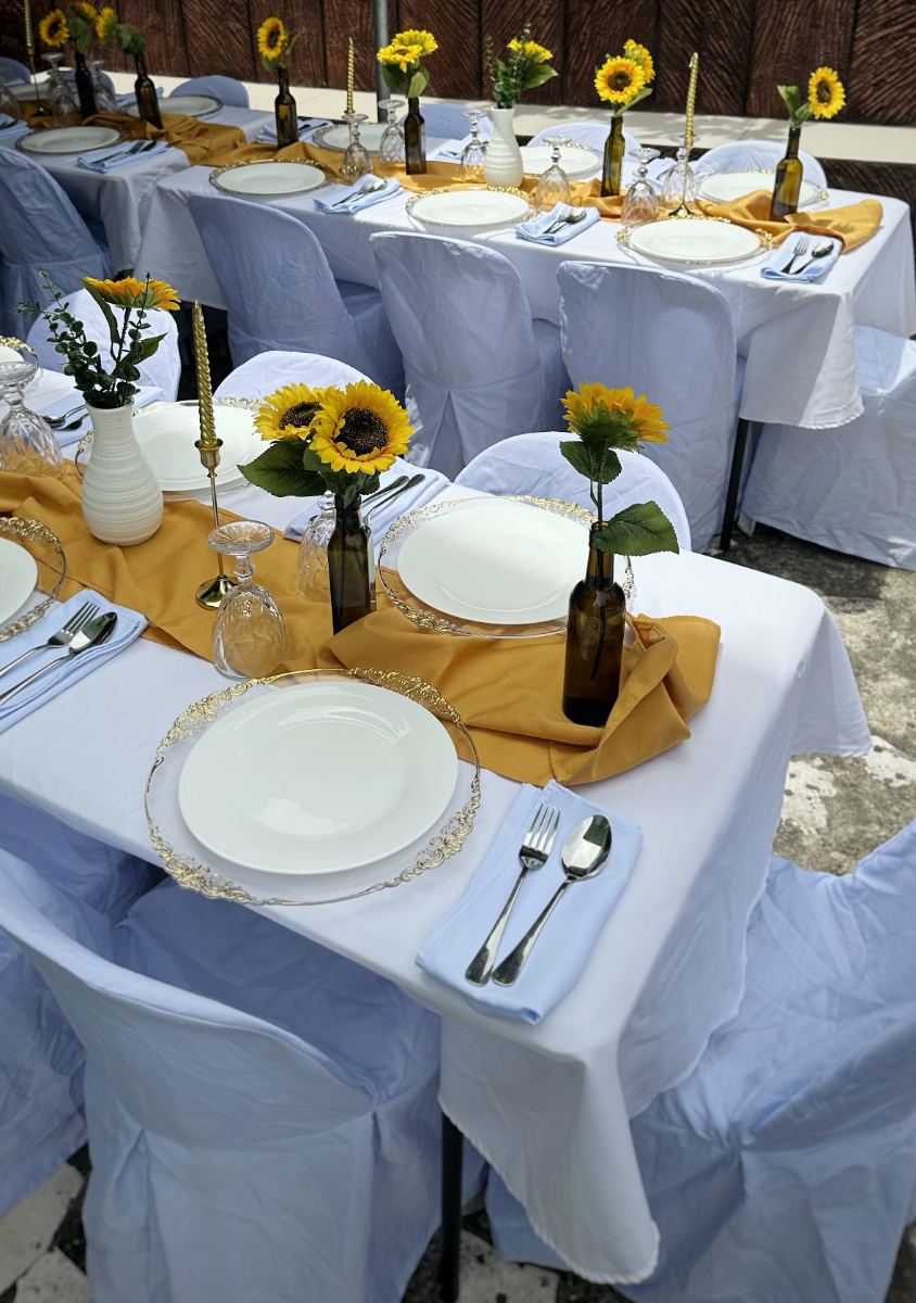 Sunflower themed dinner setup with gold runners, charger plates and full place settings